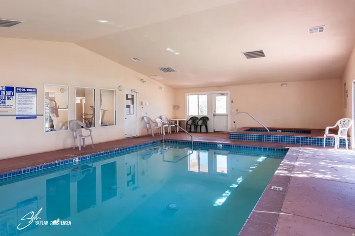Indoor swimming pool with blue tile coping and a surrounding concrete deck