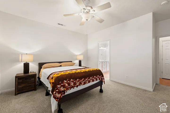 Carpeted room featuring white walls and a ceiling fan with light fixture