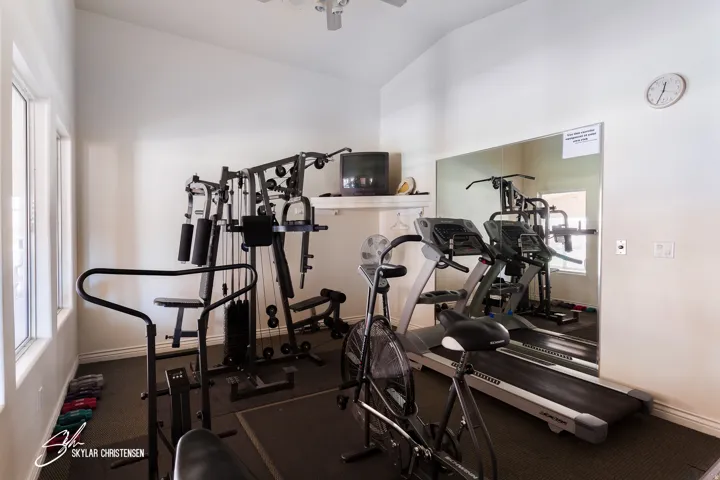 Dedicated exercise room featuring a vaulted ceiling and dual pane windows