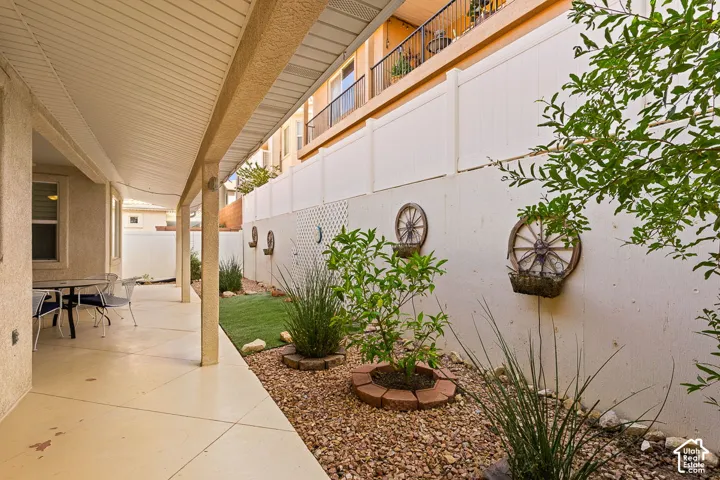 Covered patio with concrete flooring, stucco exterior, and slatted ceiling