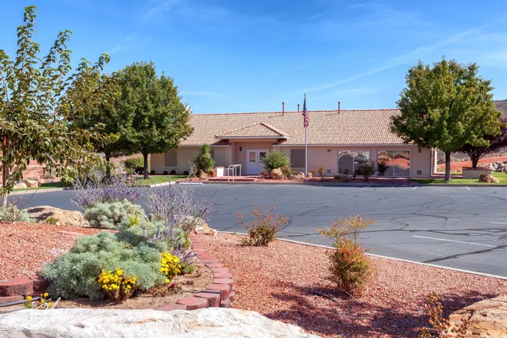 Southwestern-style building with a tile roof and a spacious parking area