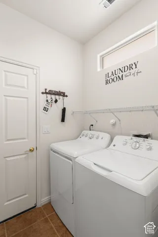 Dedicated laundry area with a white paneled door, ceramic tile flooring, and a high transom window