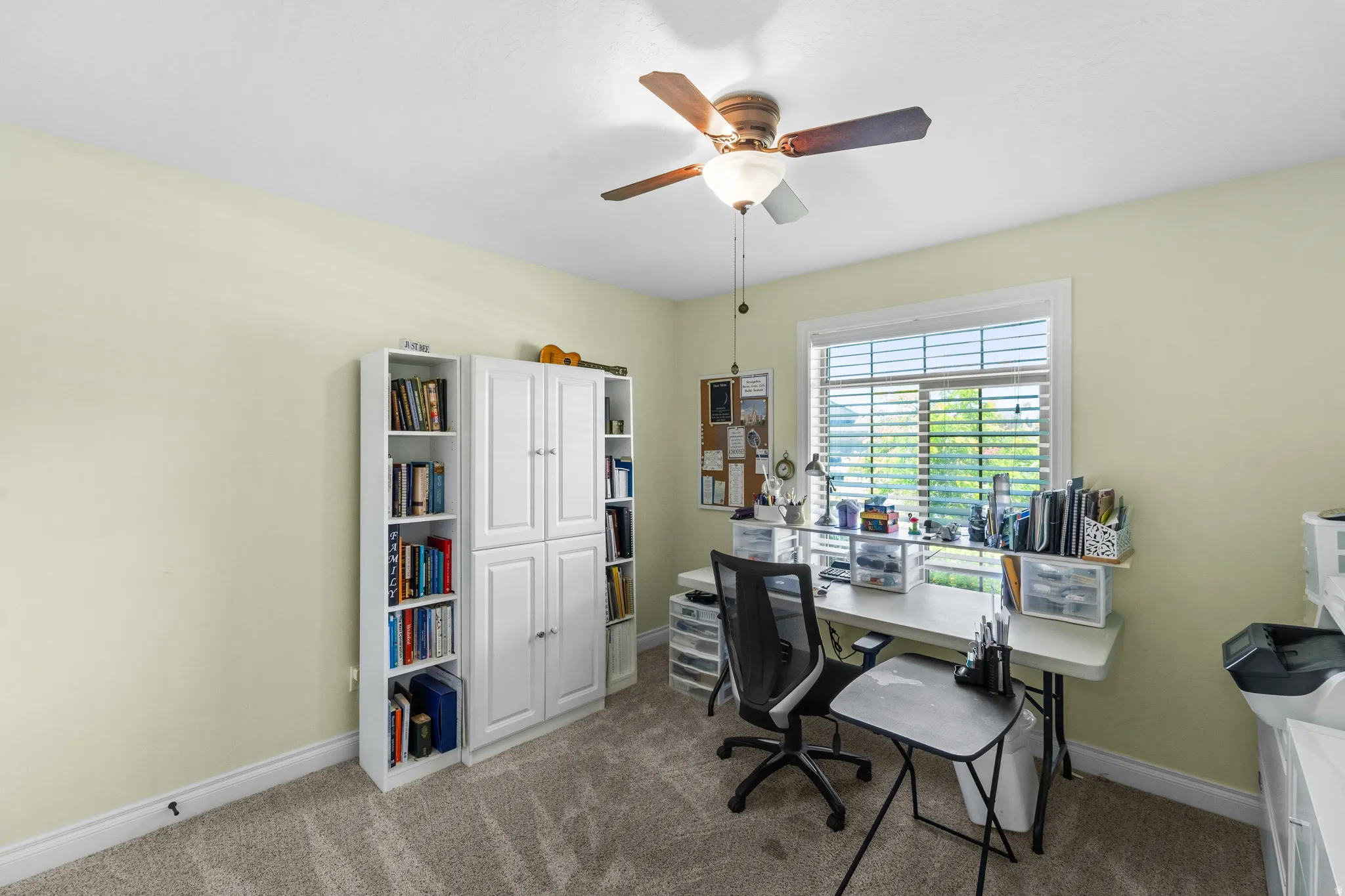 Room featuring carpet flooring, a ceiling fan with light fixture, and a window with blinds