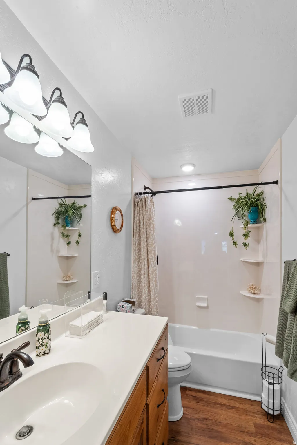 Bathroom featuring a single vanity with wood cabinetry, a white countertop, and an undermount sink