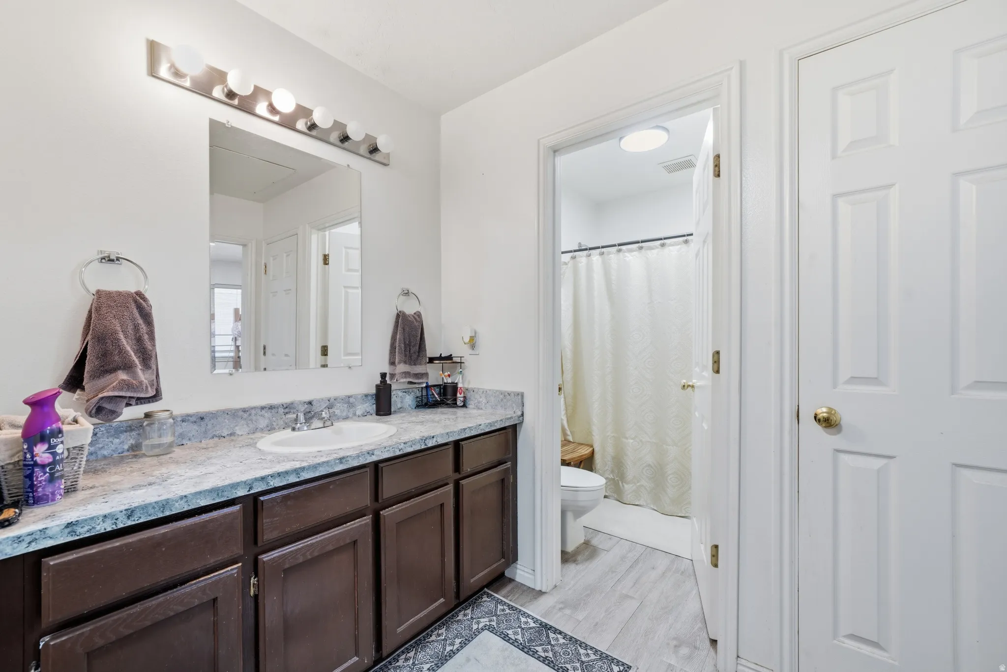 Vanity with an integrated sink, stone-finish countertop, and dark wood-finish cabinetry