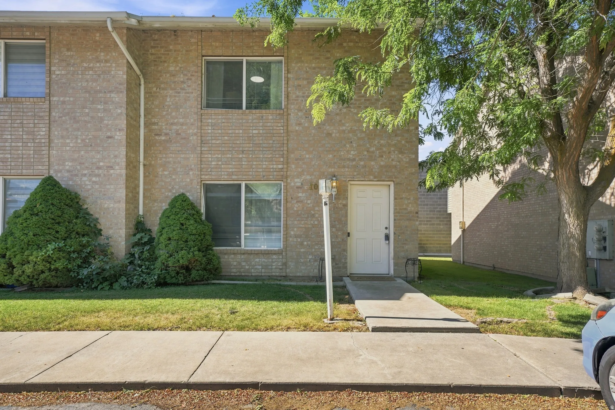 Brick veneer exterior with a concrete walkway leading to the entrance