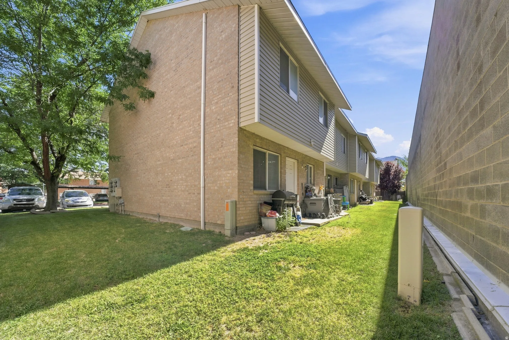 Rear exterior of a multi-unit property featuring light brick and horizontal siding
