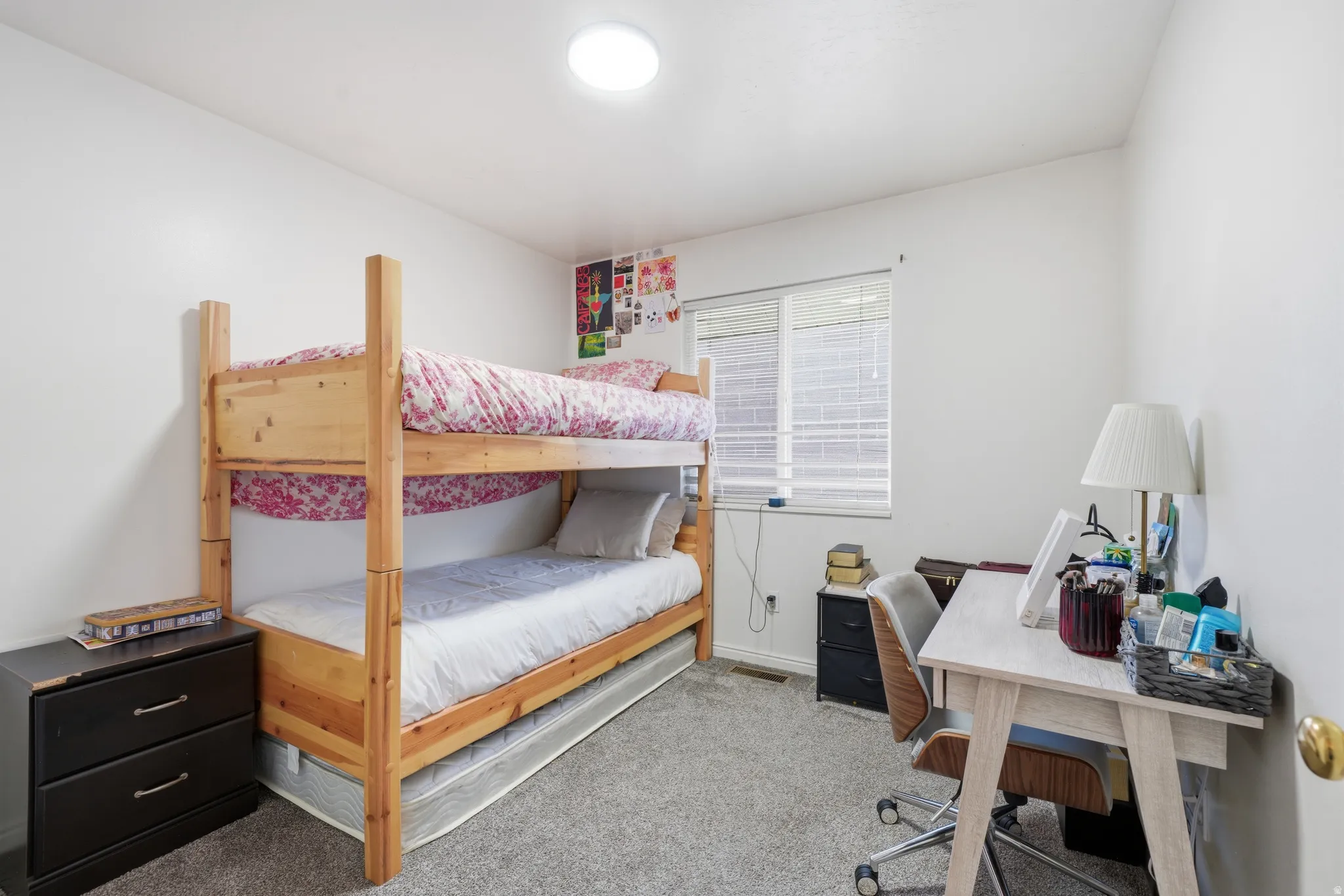 Carpeted room featuring a window with blinds, overhead lighting, and white walls