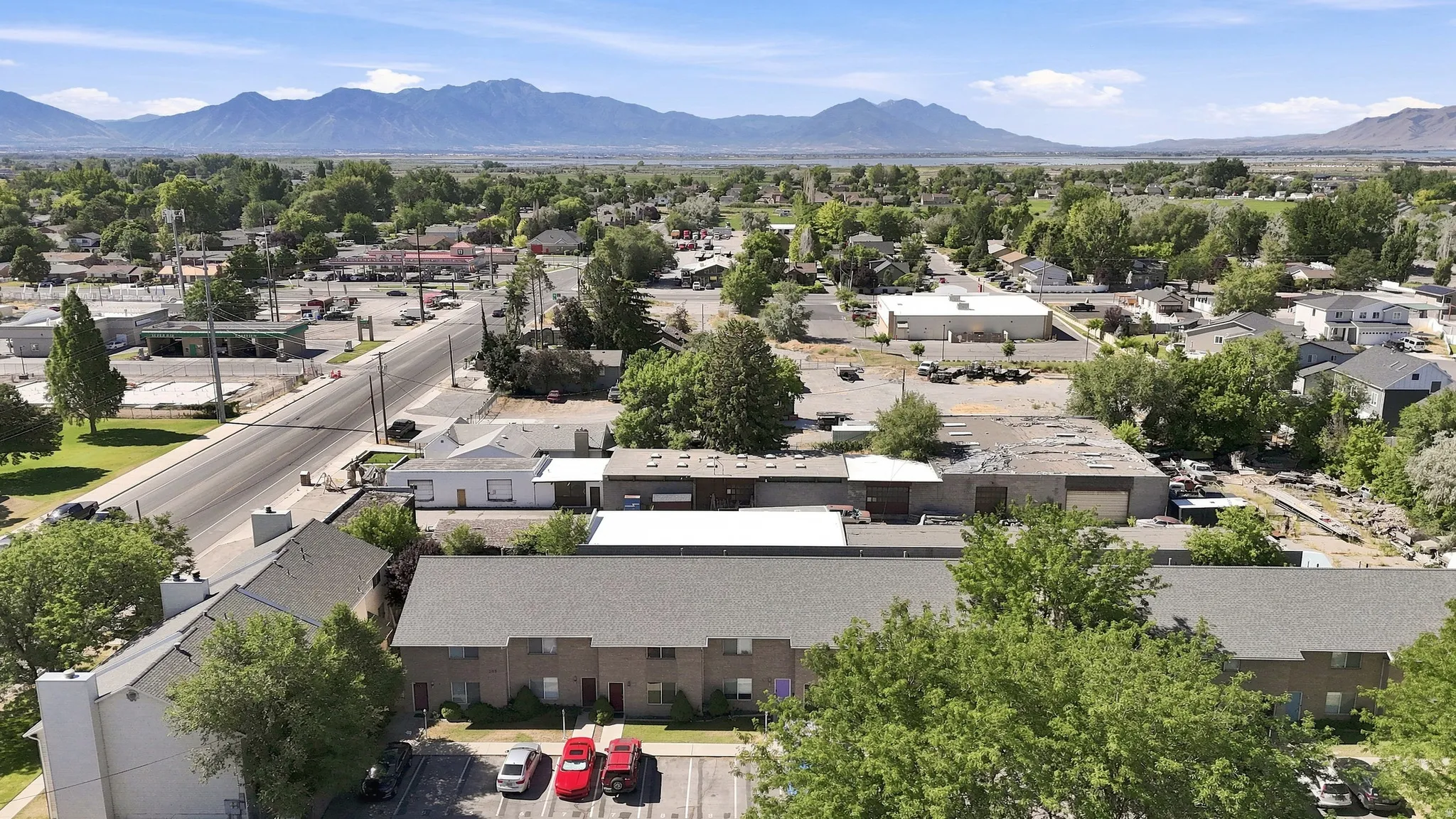 Expansive aerial perspective showcasing a townscape with verdant trees and distant mountains