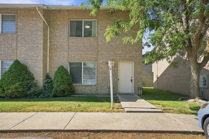 Brick veneer exterior with a concrete walkway leading to the entrance