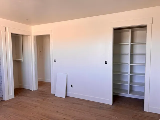 Built-in shelving, wood-finish flooring, and white trim work
