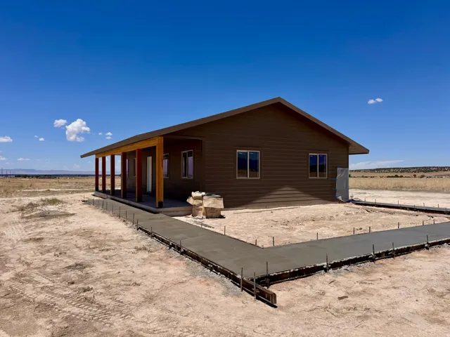 Single-story brown-sided residence featuring a covered front porch with natural wood posts