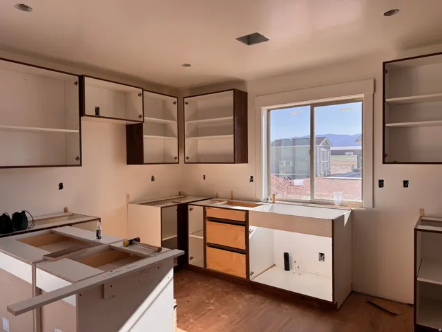 Kitchen featuring upper cabinetry, lower cabinetry, a double-hung window, and recessed lighting