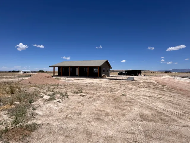 Single-story property with a covered front porch featuring exposed wood posts, horizontal siding, and a light-colored roof