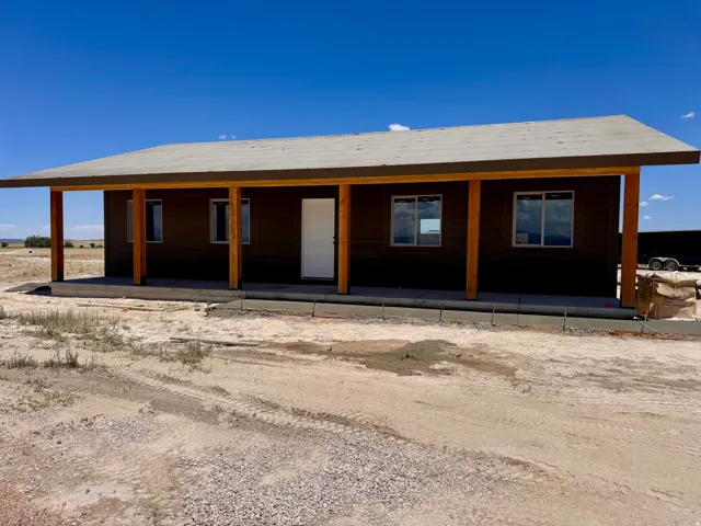 Front exterior showcasing a deep covered porch supported by natural wood posts