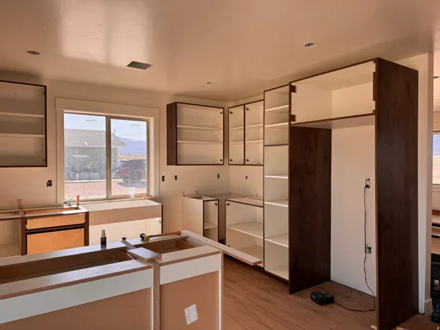 Kitchen featuring dark wood-finish cabinetry, recessed lighting, wood-finish flooring, and a double window