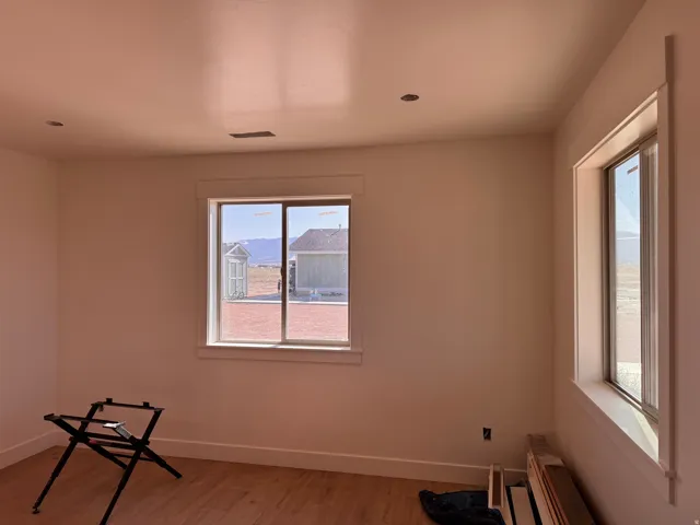 Recessed ceiling lighting, wood-finish flooring, multiple windows, and crisp white trim