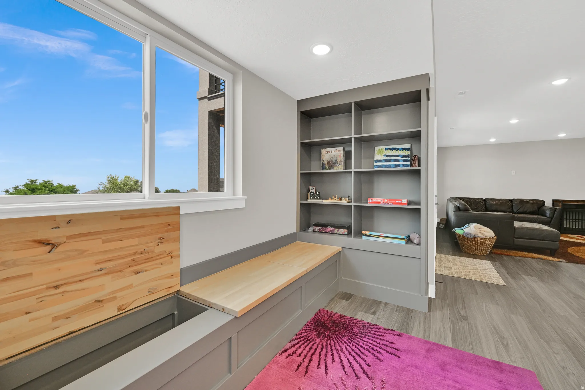 Built-in window bench with storage, integrated shelving, and wood-finish flooring