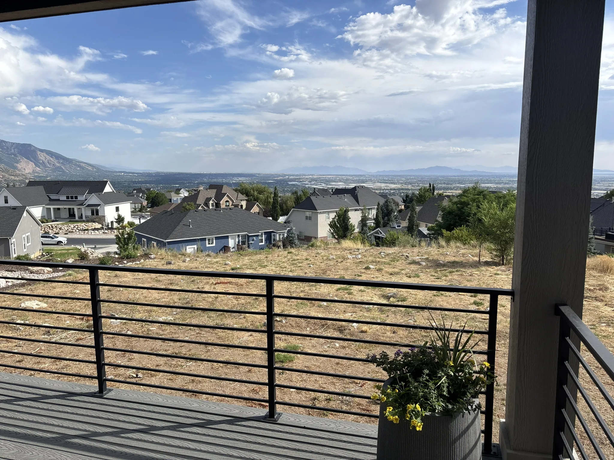 Expansive mountain and city vistas from a composite deck featuring a horizontal bar railing