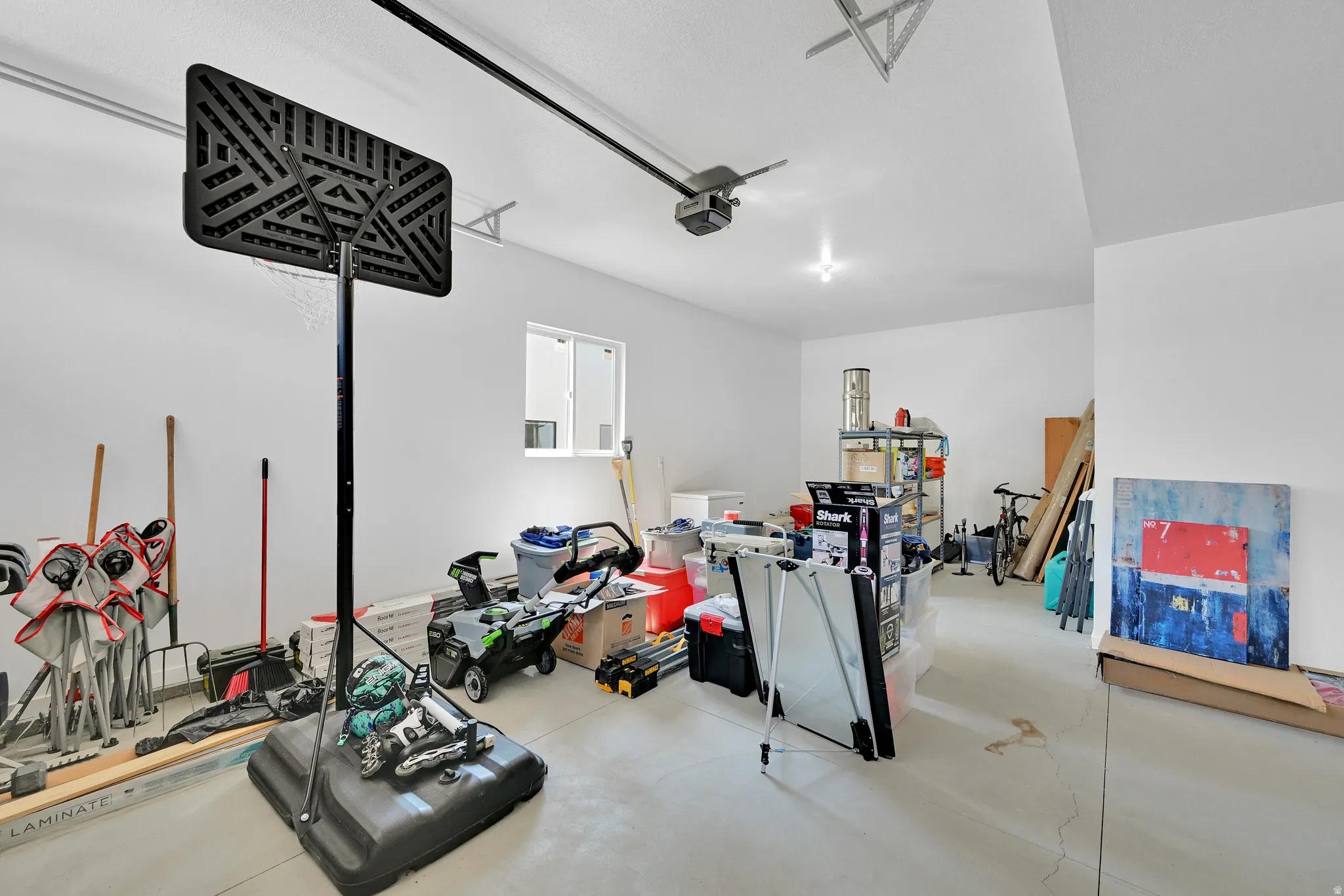 Spacious garage featuring a concrete floor, white painted walls, and a window for natural light