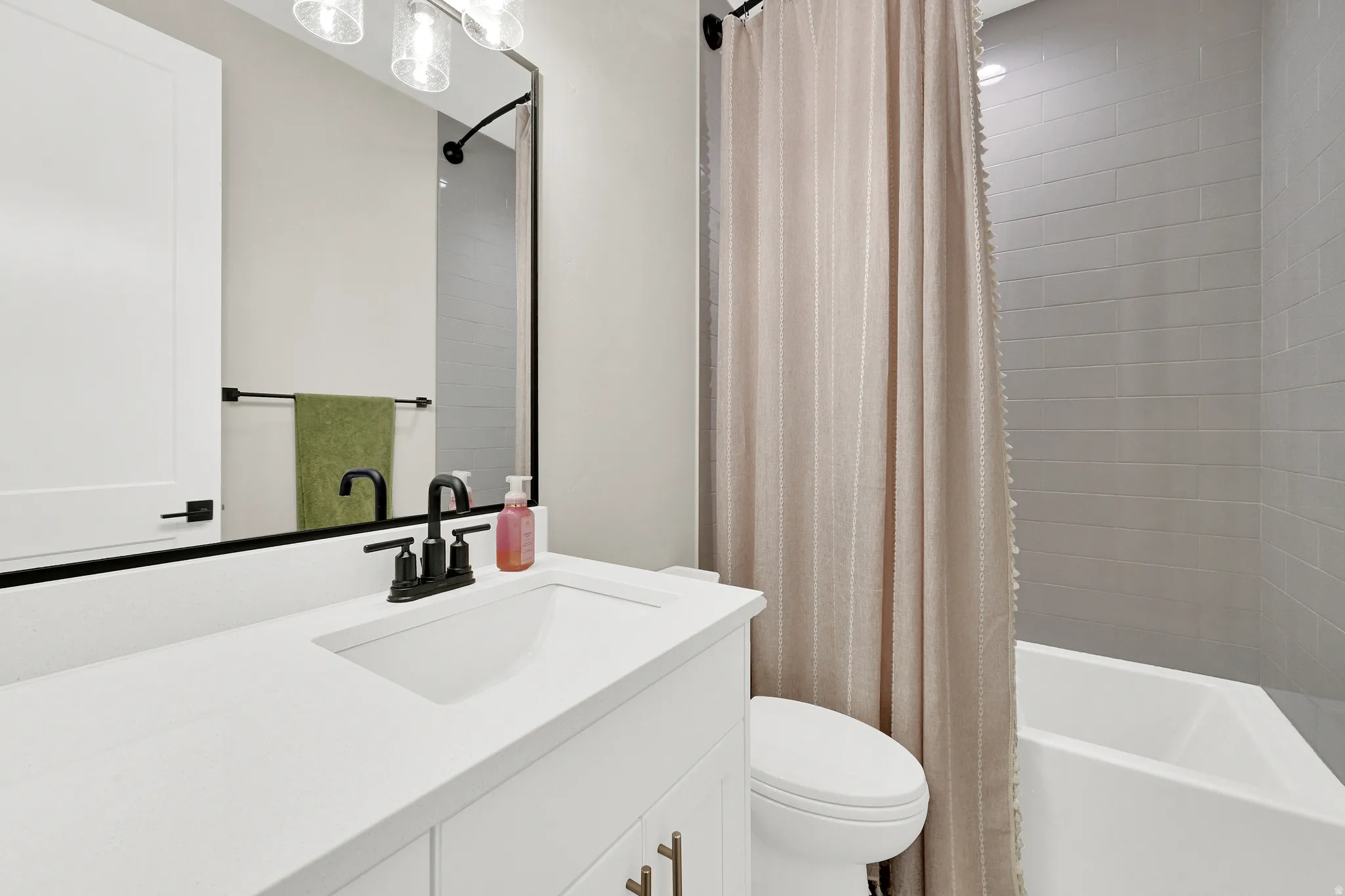 Bathroom featuring a white vanity with a rectangular sink, matte black faucet, and a large framed mirror