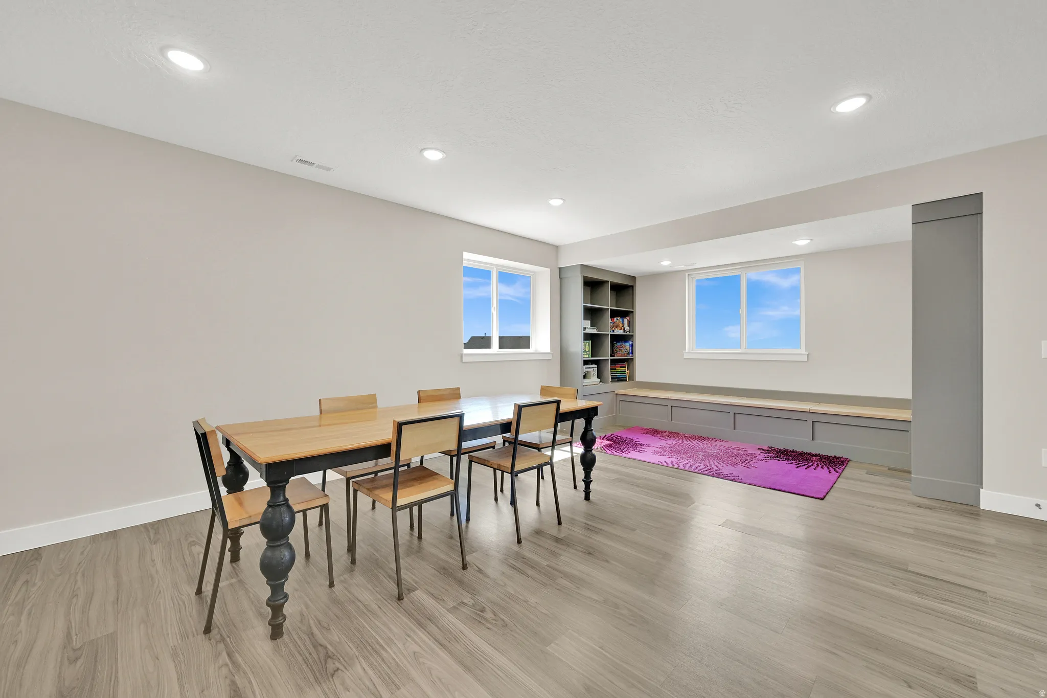 Spacious lower-level room featuring wood-finish flooring, recessed lighting, and neutral wall tones