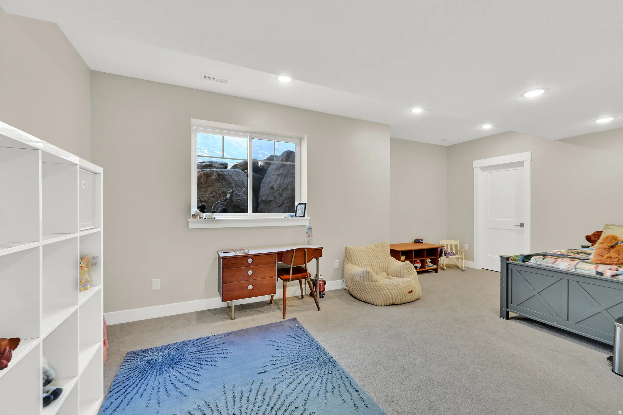 Spacious room featuring neutral carpeting, recessed lighting, a white trim window, and a crisp white interior door