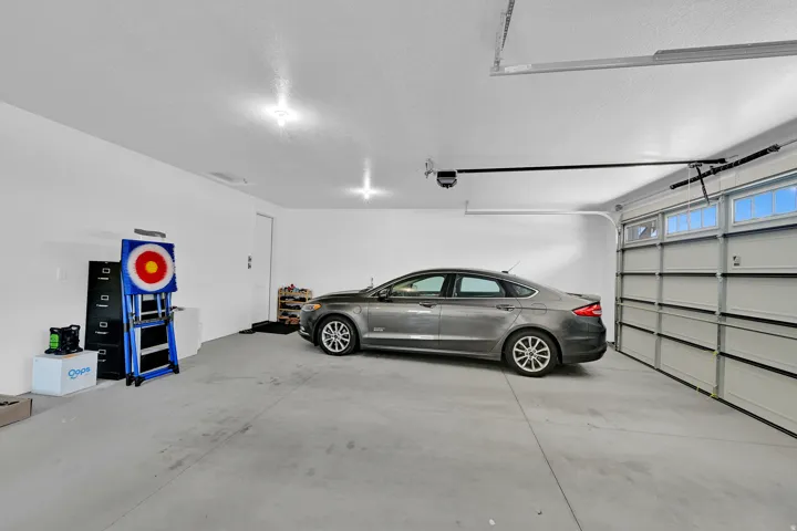 Spacious garage featuring a concrete floor, bright overhead lighting, and a two-car capacity