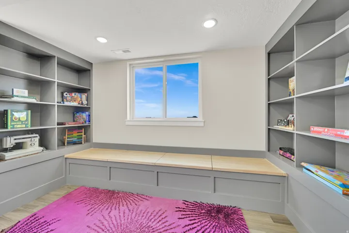 Built-in shelving units flank a window seat with natural wood tops