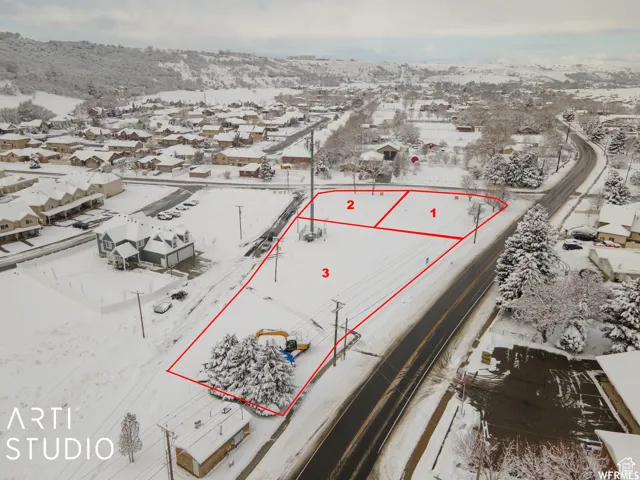 Expansive land parcel featuring clear demarcation, road frontage, utility poles, and surrounding residential structures