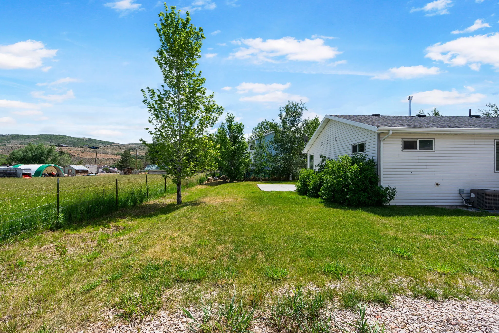 Expansive green lawn bordering a wire fence