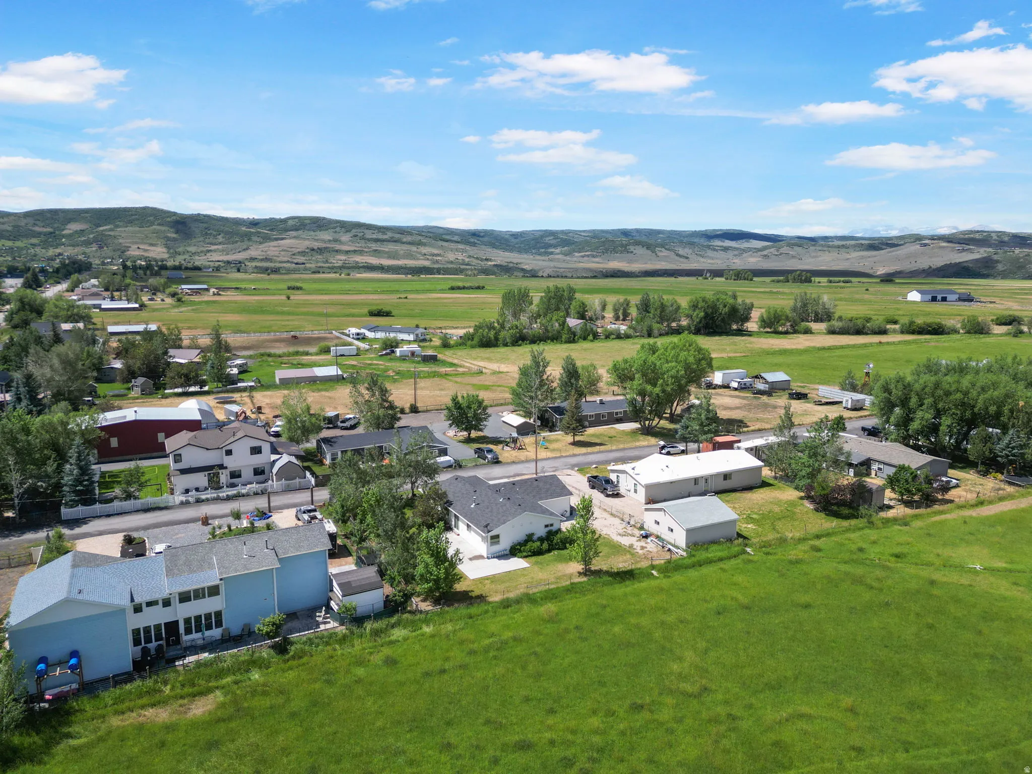Expansive green landscape featuring distant mountains and a residential area