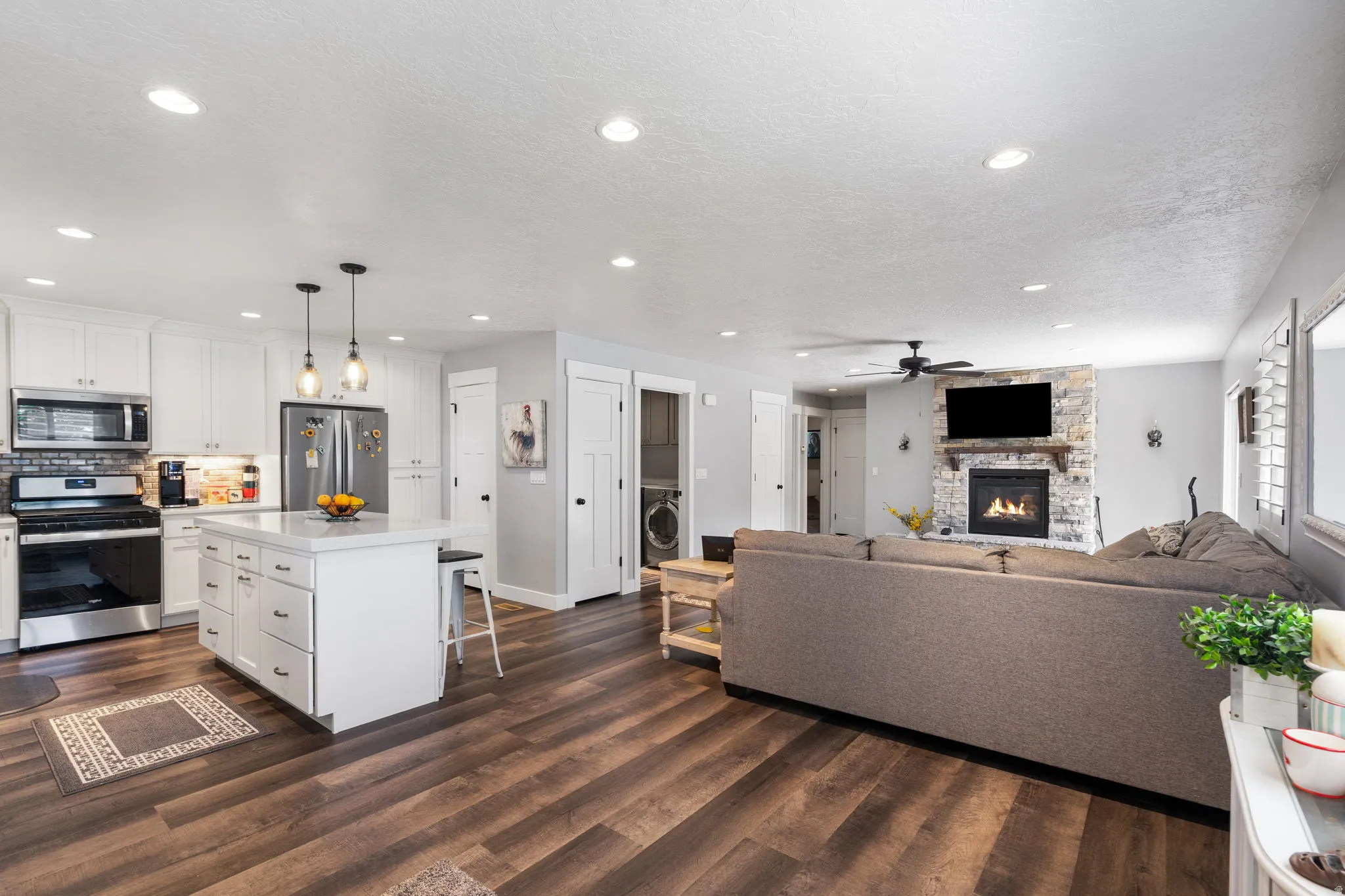 Expansive kitchen and living area featuring wood-finish flooring