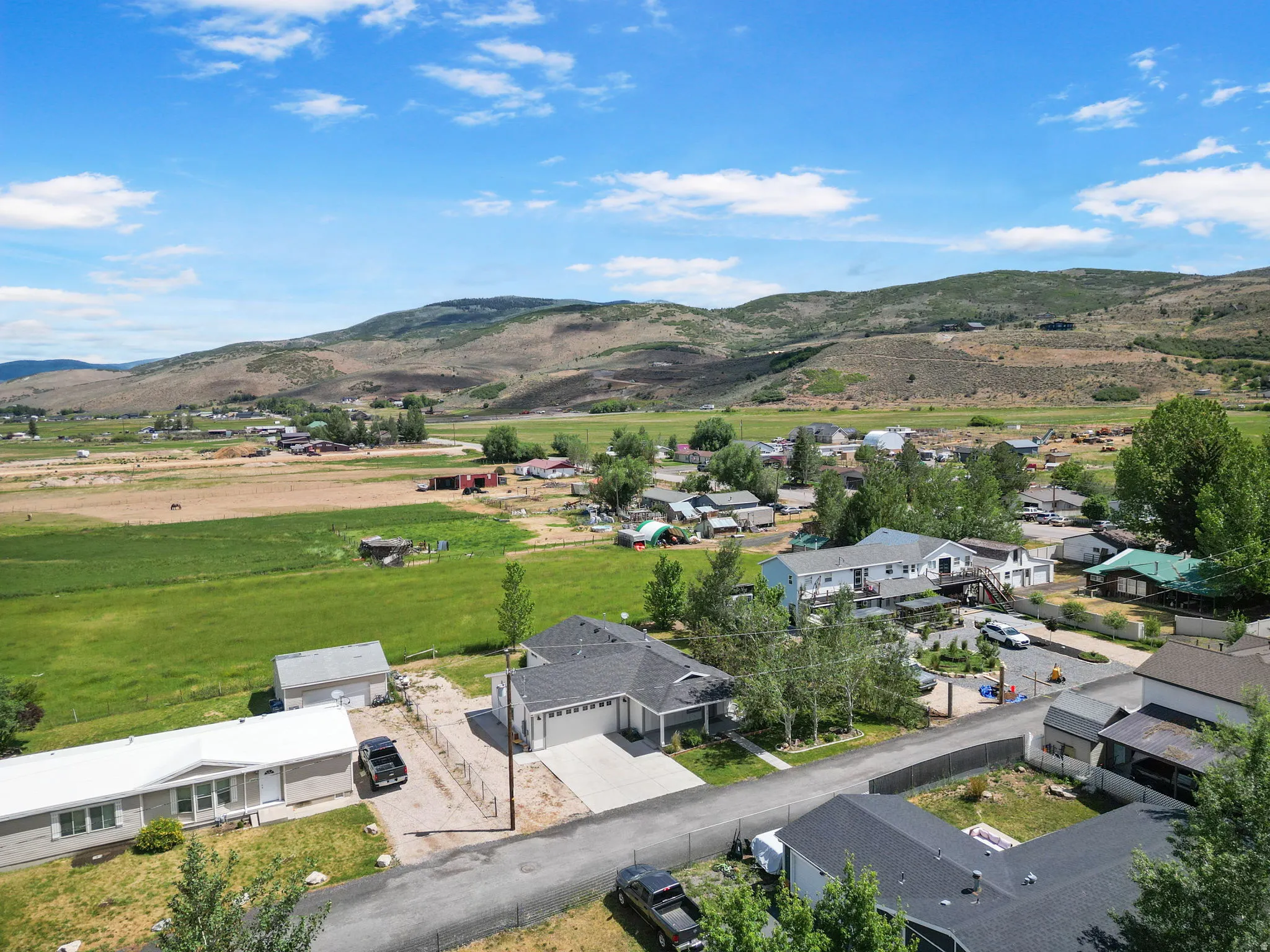 Expansive rural landscape featuring distant mountains, fields, and a residential community