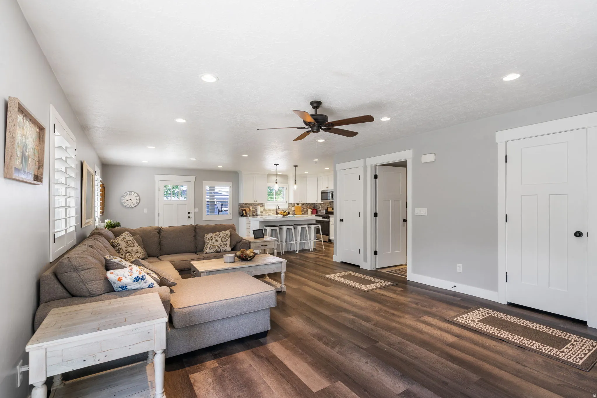 Open-concept living space featuring wood-finish flooring, recessed lighting, and a ceiling fan