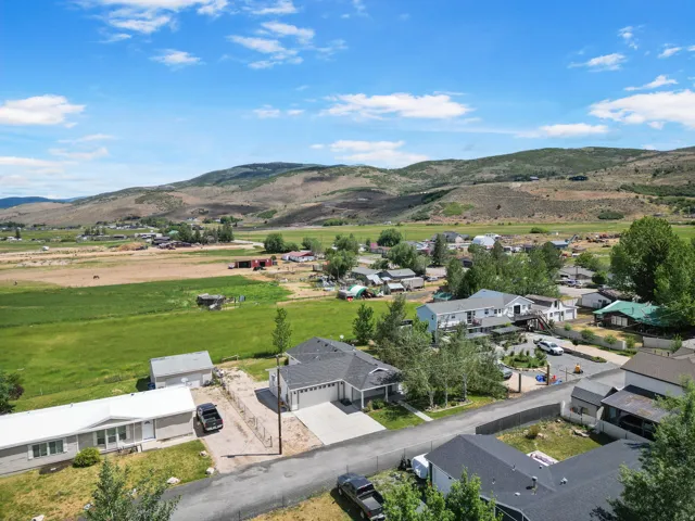 Expansive rural landscape featuring distant mountains, fields, and a residential community