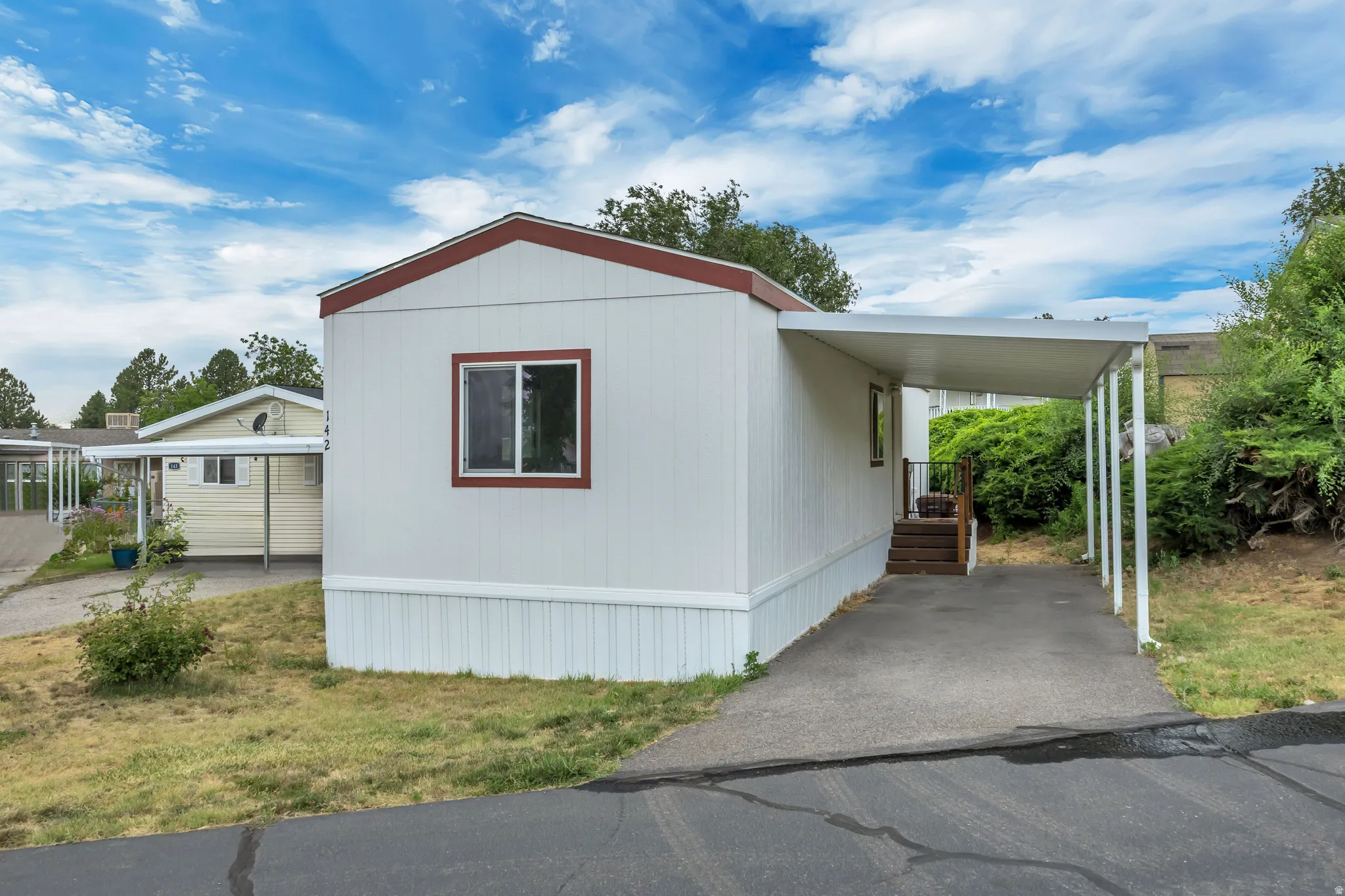 White siding exterior with a red trim roofline