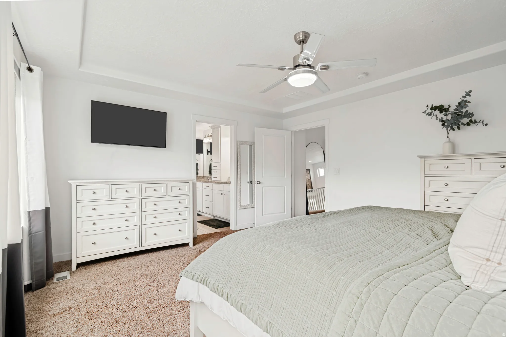 Carpeted interior room featuring a tray ceiling, recessed lighting, and a ceiling fan with integrated lighting