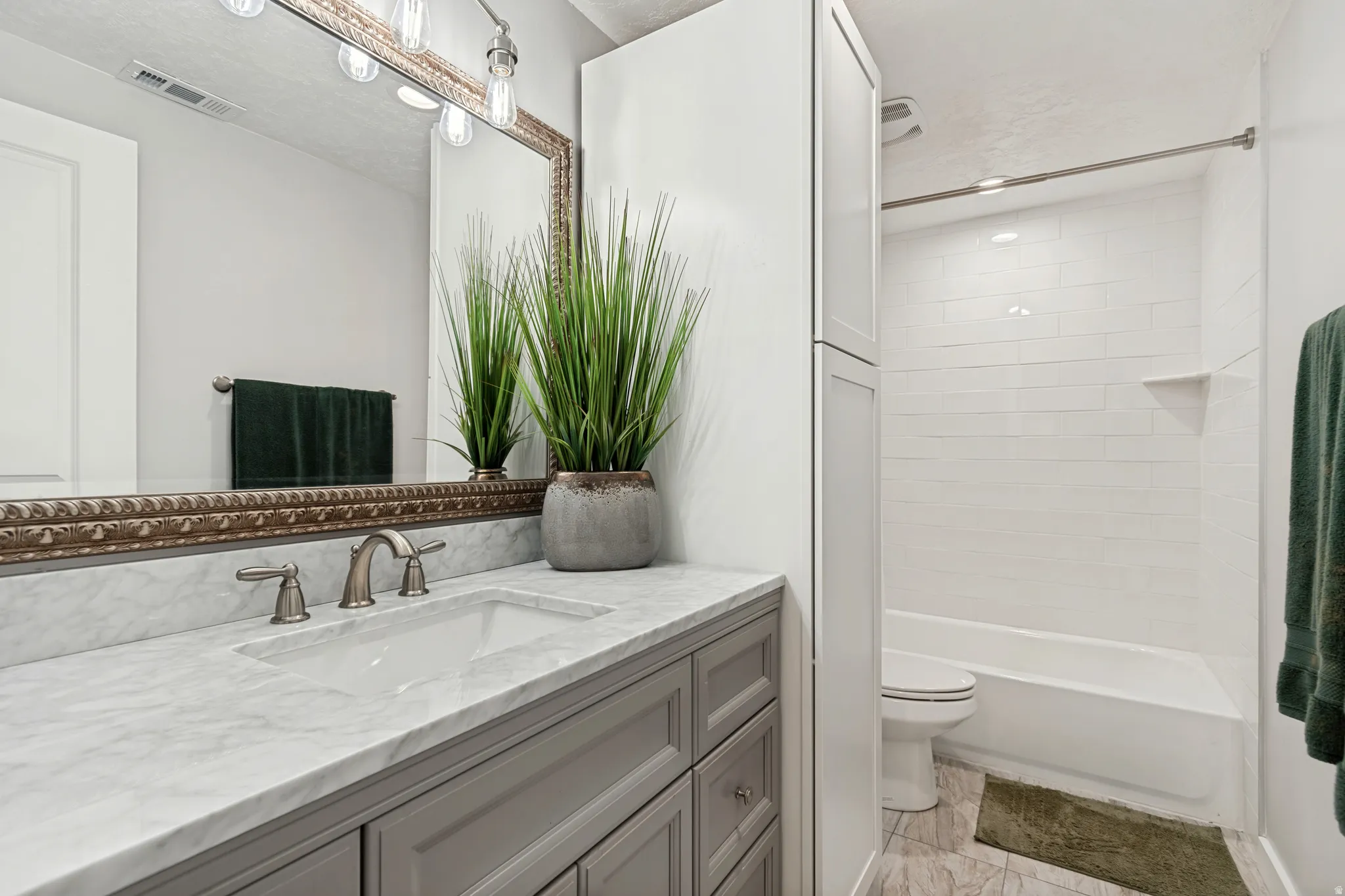 Bathroom featuring a vanity with a white stone countertop, undermount sink, and brushed nickel faucet