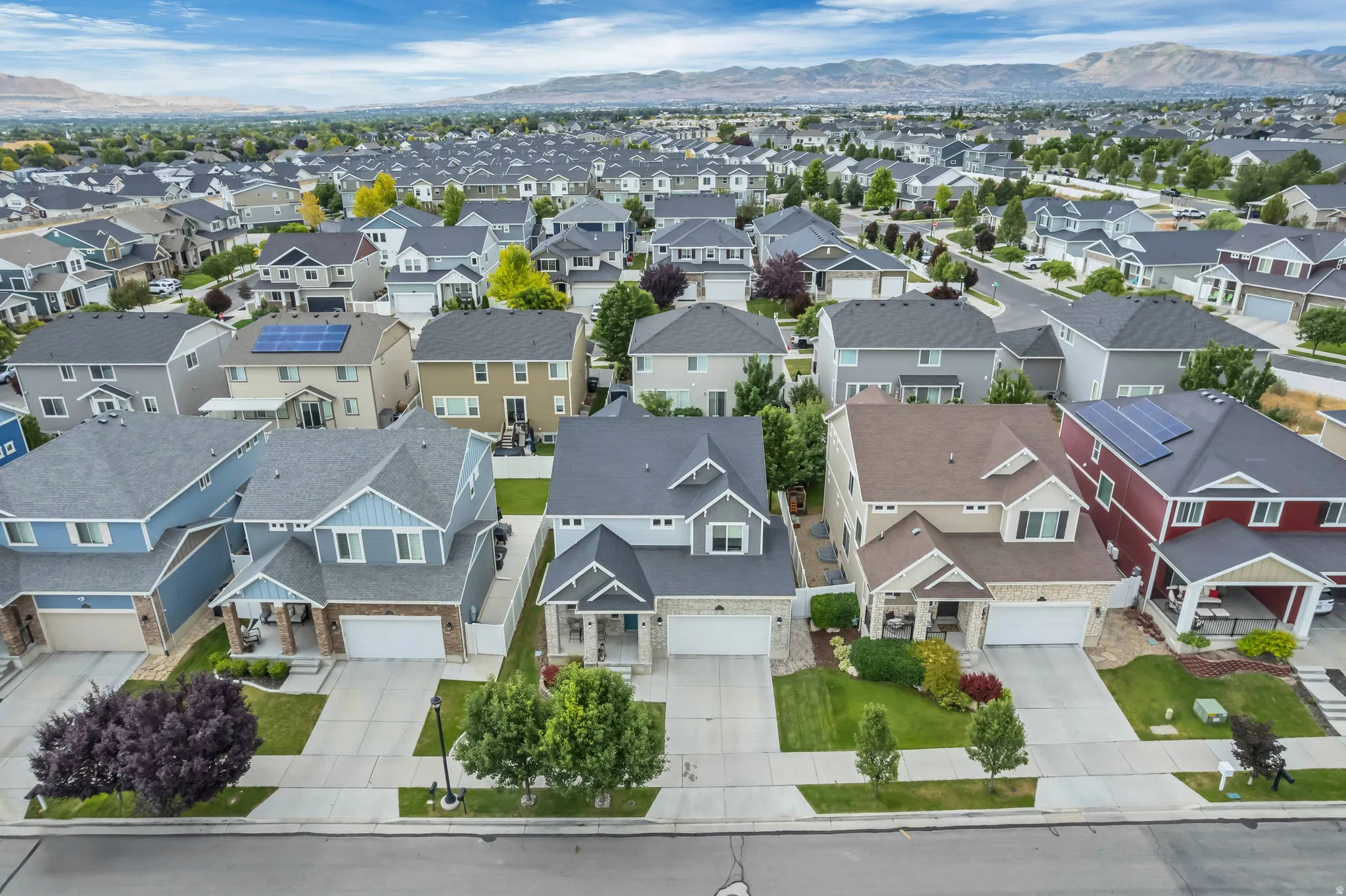 Residential neighborhood featuring varied single-family homes with mature landscaping and mountain range backdrop