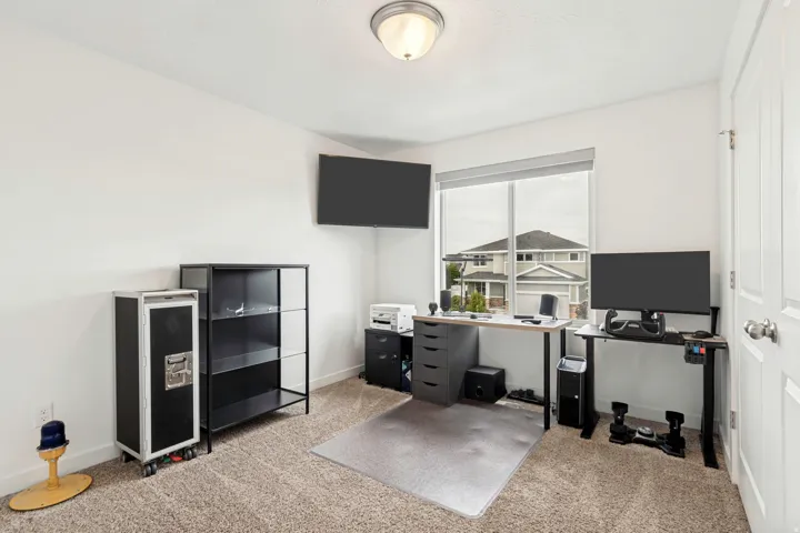 Carpeted room with white walls, a semi-flush mount ceiling light, and a large window