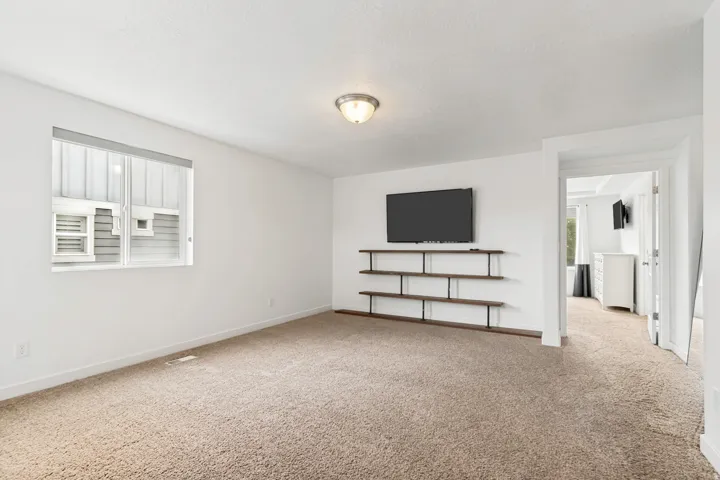 Spacious room featuring neutral carpeting and white wall finishes