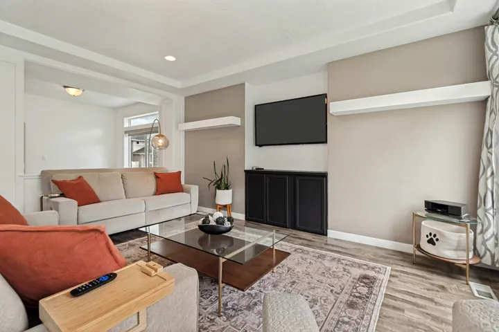 Spacious open-concept living area featuring wood-finish flooring and recessed lighting