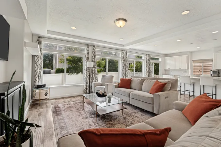 Open-concept living area featuring wood-finish flooring and ample natural light from multiple windows