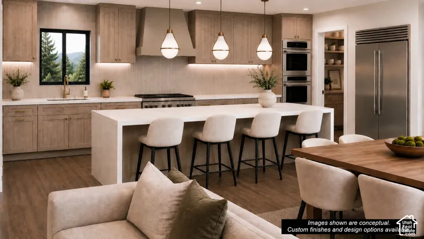 Spacious kitchen featuring light-toned cabinetry, a large waterfall island with seating, stainless steel appliances, and a built-in pantry