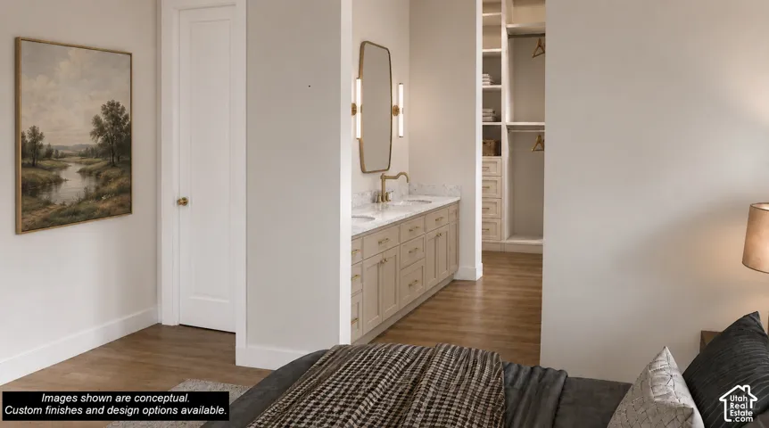 Bathroom vanity featuring dual sinks, a stone countertop, and custom cabinetry with brass hardware