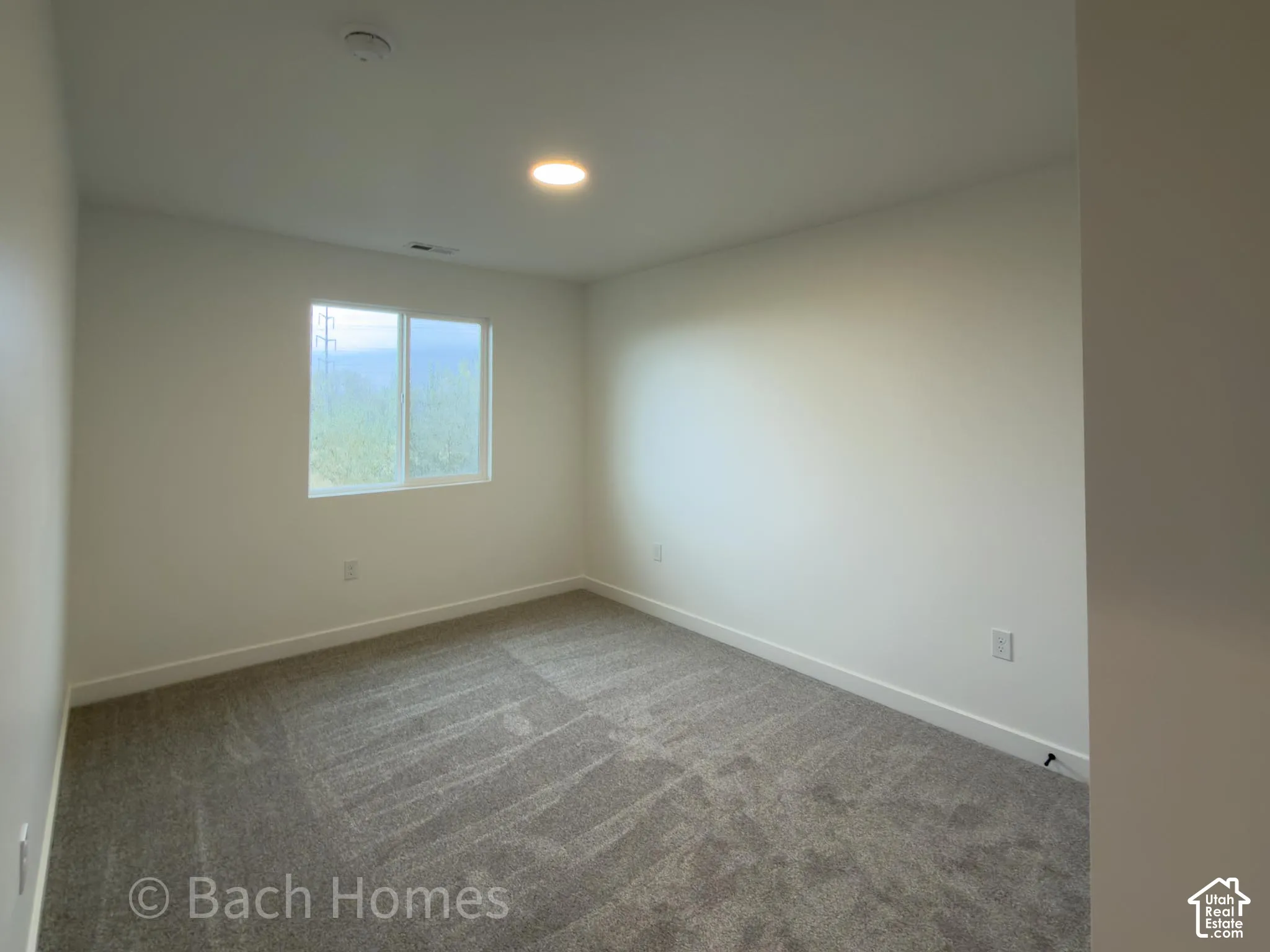 Neutral-toned wall-to-wall carpeting, single-pane slider window, and recessed ceiling lighting