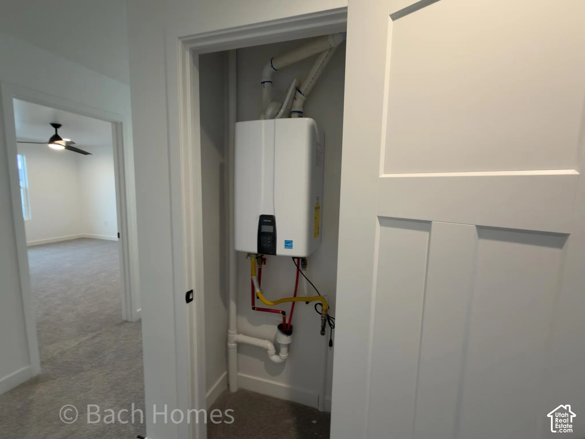 Wall-mounted tankless water heater with digital control panel and interior piping