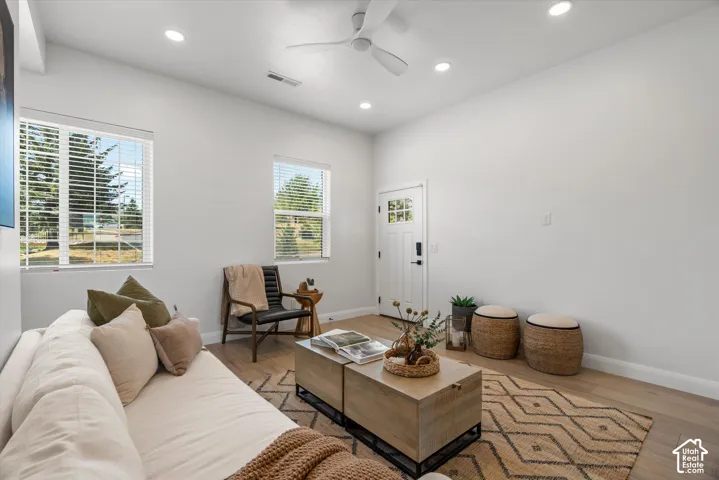 Open-concept living space featuring wood-finish flooring, recessed lighting, and a modern ceiling fan
