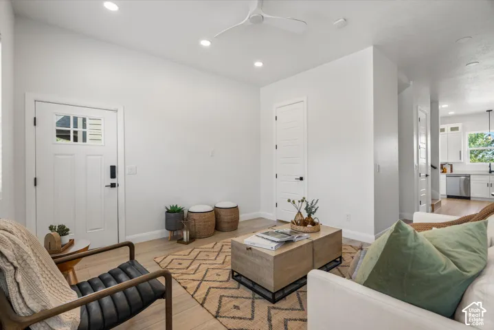 Bright open-concept living space with recessed lighting and a ceiling fan